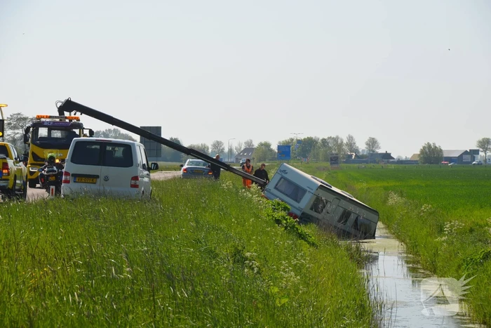 Caravan raakt los van auto en belandt in sloot