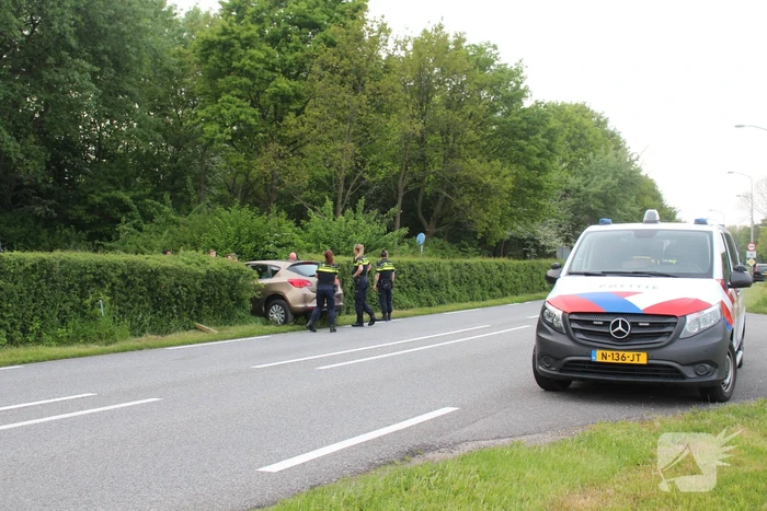 Auto rijdt dwars door heg