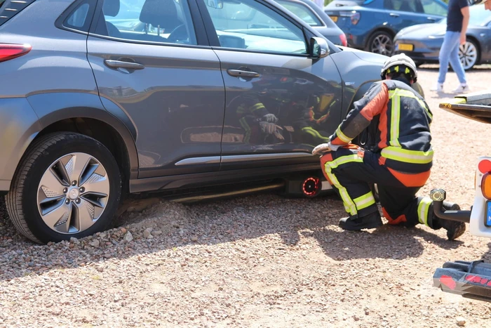 Elektrische personenauto rijdt oplaadpaal uit de grond