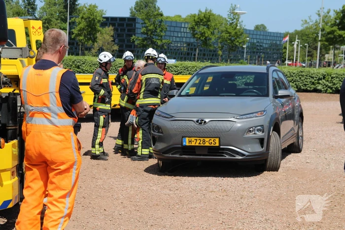 Elektrische personenauto rijdt oplaadpaal uit de grond