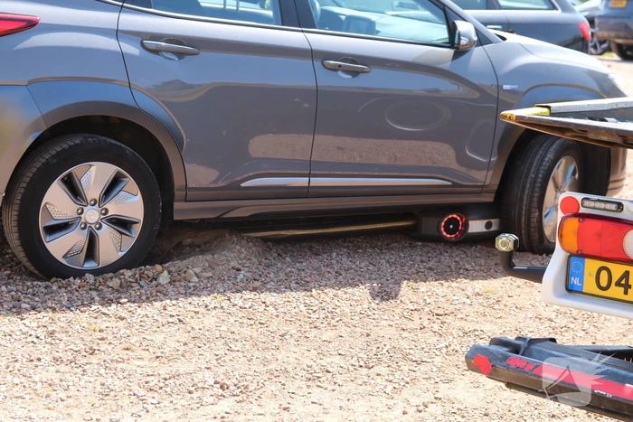 Elektrische personenauto rijdt oplaadpaal uit de grond