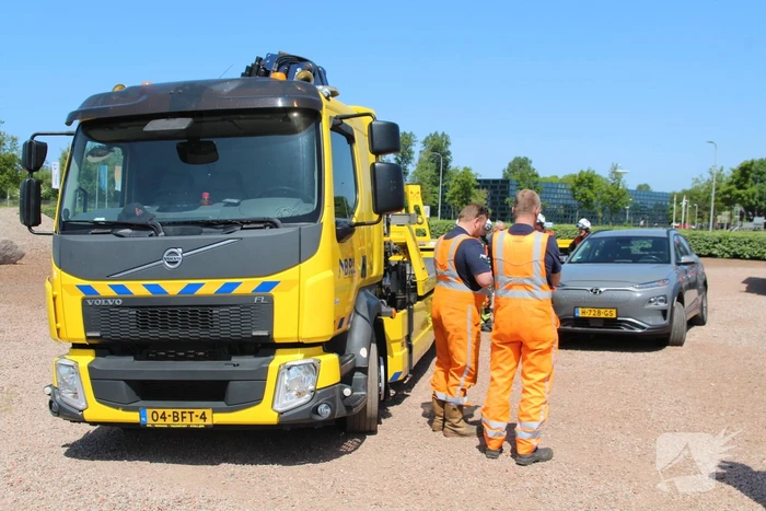 Elektrische personenauto rijdt oplaadpaal uit de grond