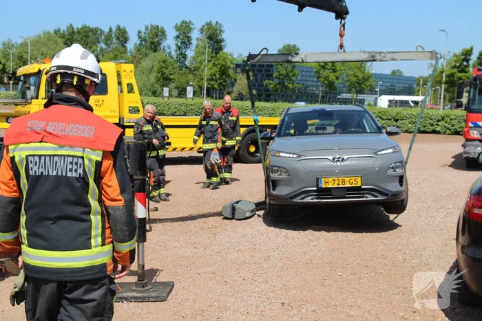 Elektrische personenauto rijdt oplaadpaal uit de grond