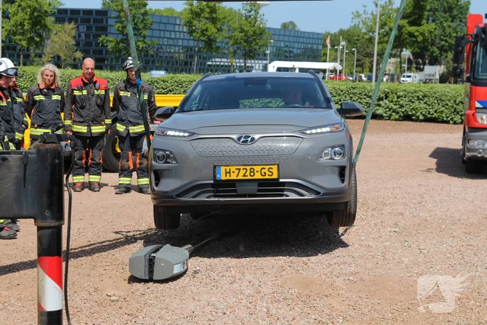 Elektrische personenauto rijdt oplaadpaal uit de grond
