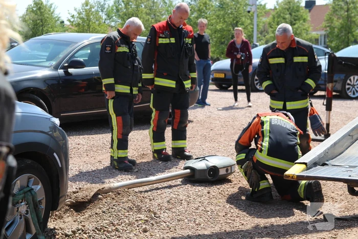Elektrische personenauto rijdt oplaadpaal uit de grond