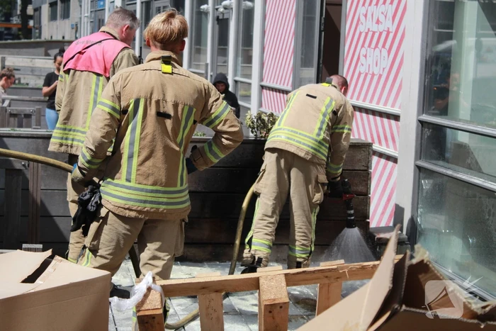 Schade aan vlonder na brand in stapel karton