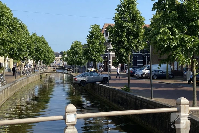Auto blijft op randje van kade hangen boven gracht