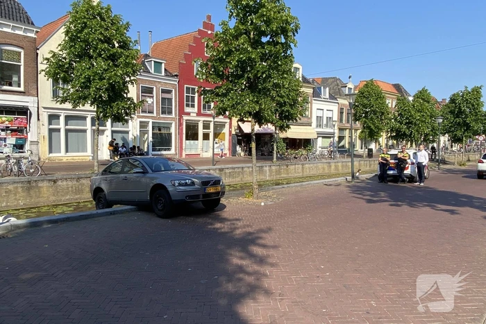 Auto blijft op randje van kade hangen boven gracht