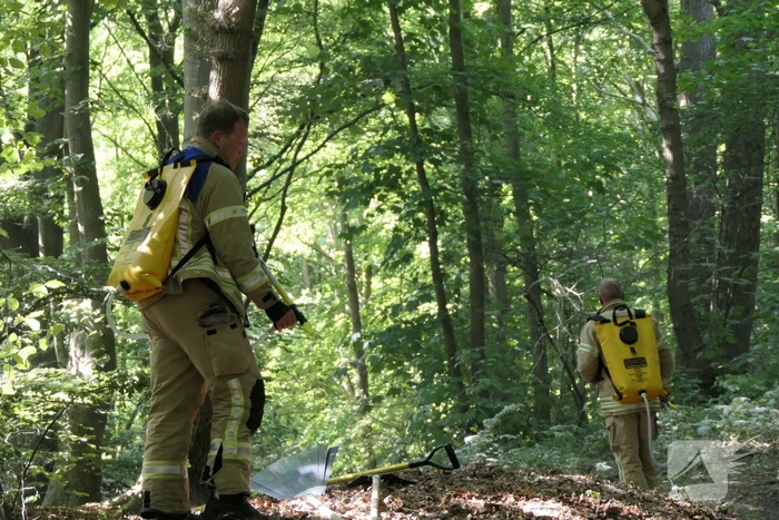 Brandweer blust smeulende delen in duingebied