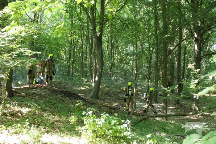 Brandweer blust smeulende delen in duingebied