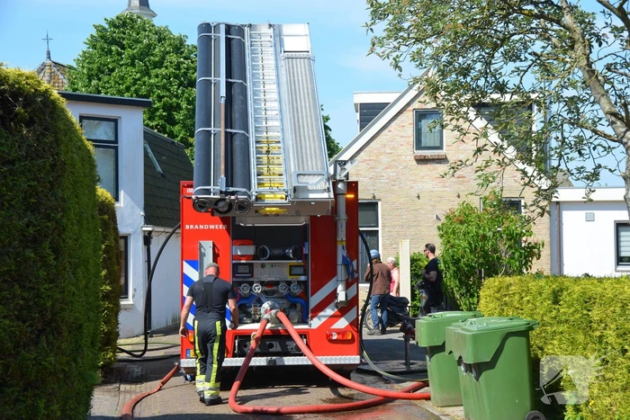 Brandweer blust dakbrand woning