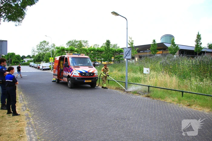 Berm in brand bij winkelcentrum