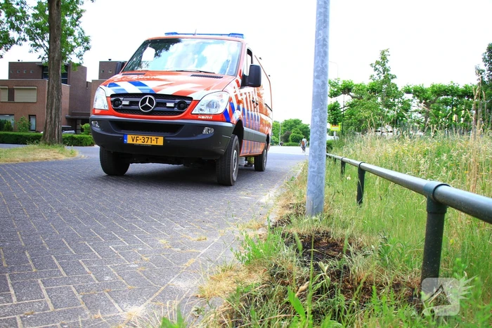 Berm in brand bij winkelcentrum