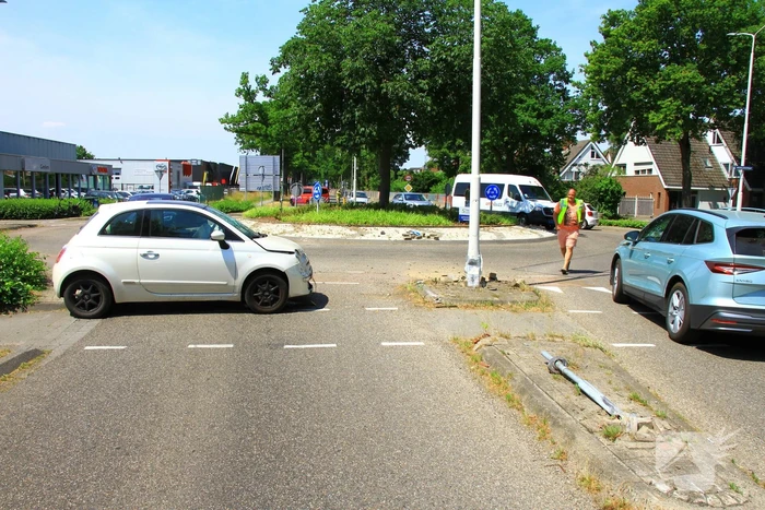 Automobilist ramt paal en lantaarnpaal bij rotonde