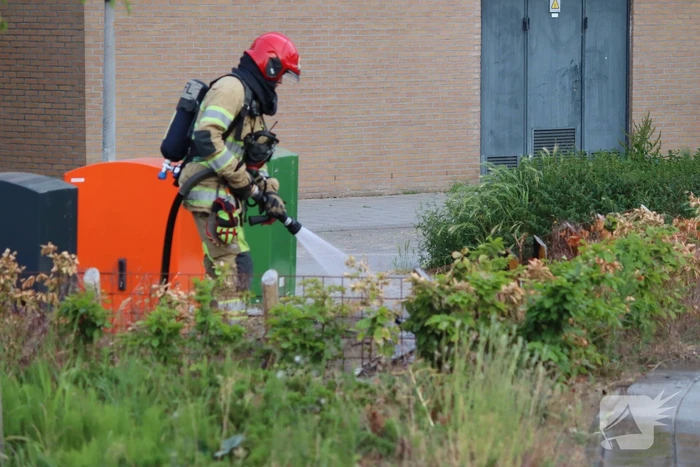 Gedumpt afval bij containers in brand