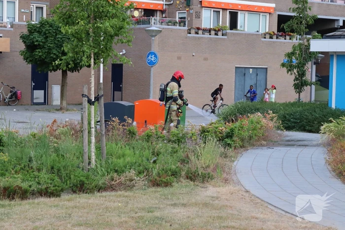 Gedumpt afval bij containers in brand