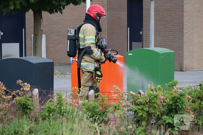 Gedumpt afval bij containers in brand
