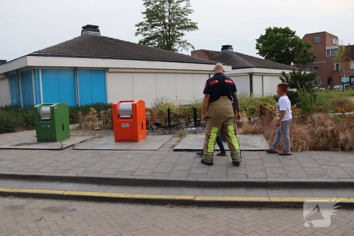 Gedumpt afval bij containers in brand