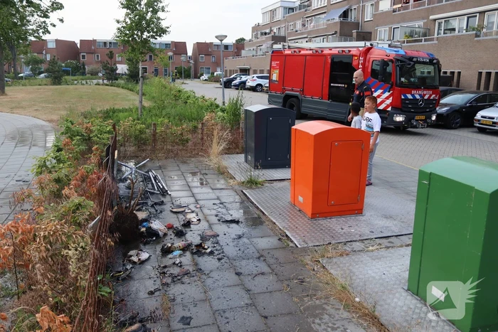 Gedumpt afval bij containers in brand