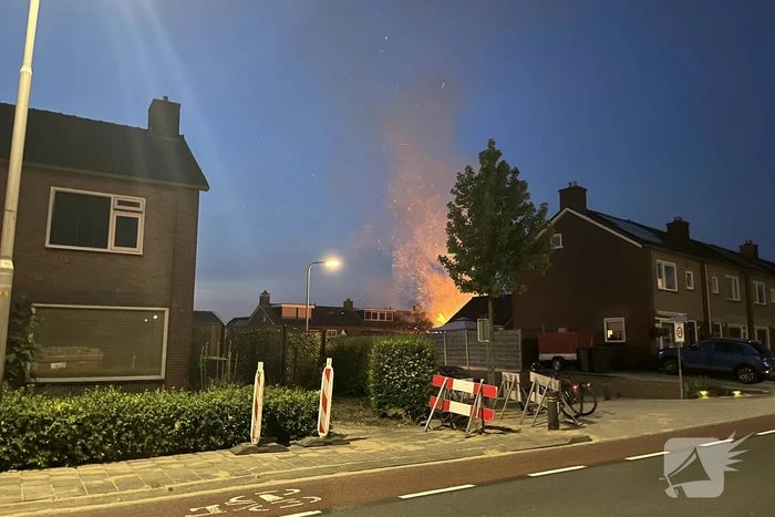 Felle brand in struiken van achtertuin