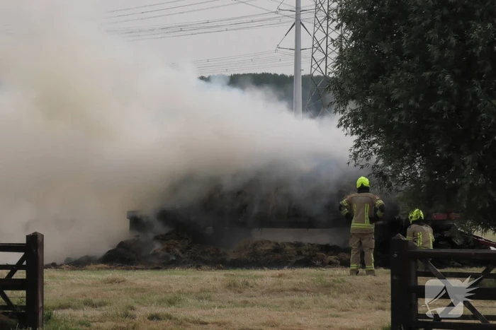 Trailer geladen met hooibalen uitgebrand in weiland