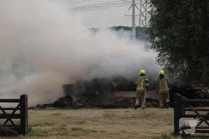 Trailer geladen met hooibalen uitgebrand in weiland