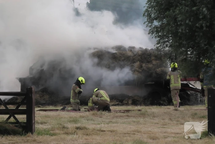 Trailer geladen met hooibalen uitgebrand in weiland
