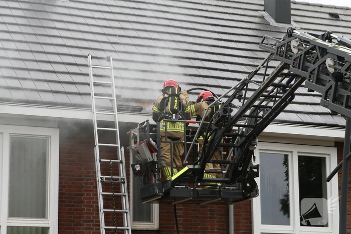 Brandweer sloopt dak bij brand