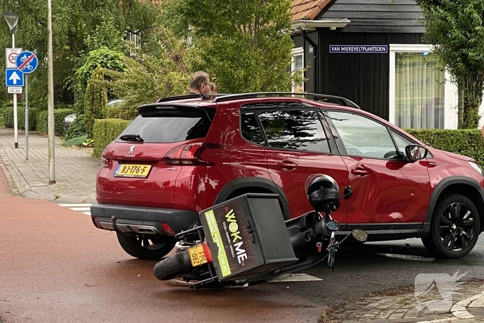 Automobilist en bezorger in botsing op kruising