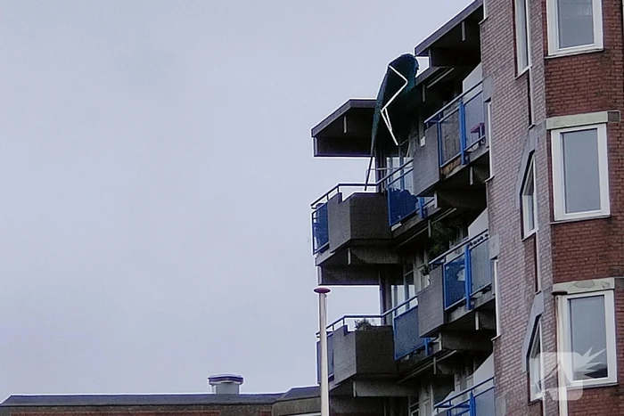 Brandweer verwijderd losgewaaid zonnescherm