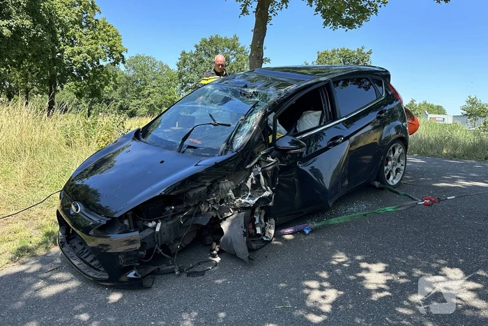 Auto belandt op de kop na botsing tegen boom