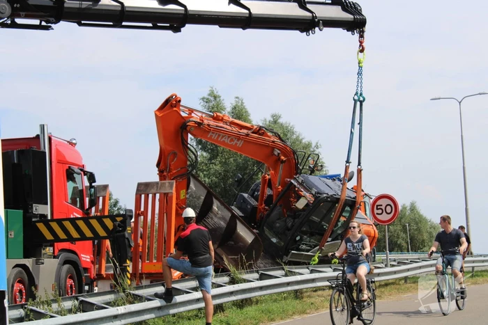 Graafkraan valt van dieplader