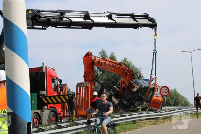 Graafkraan valt van dieplader