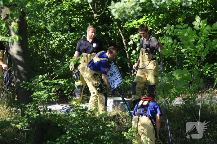 Brandweer haalt fiets en verkeersbord uit water