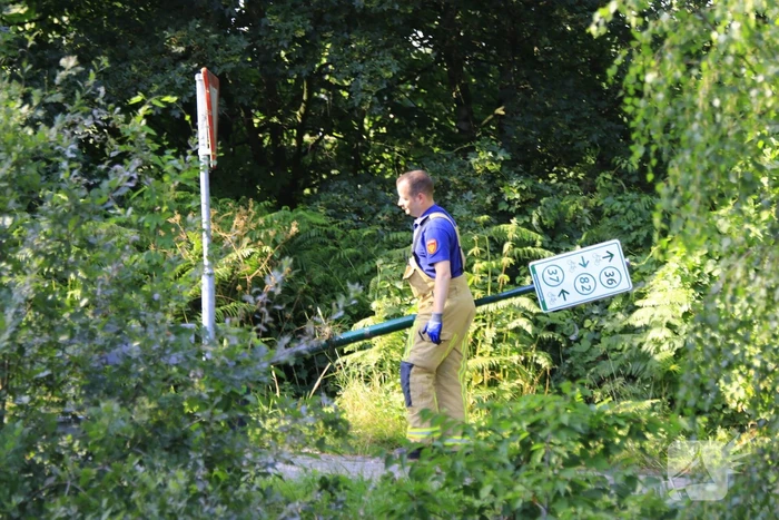 Brandweer haalt fiets en verkeersbord uit water