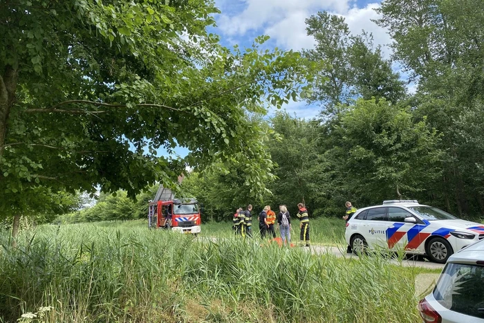 Vrouw rijdt met driewieler de sloot