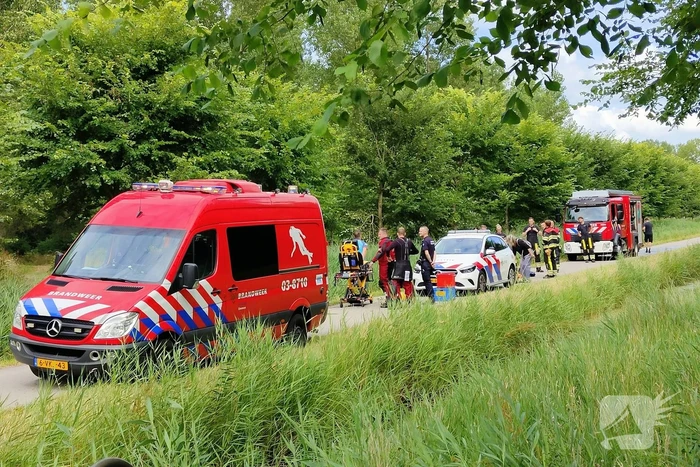 Vrouw rijdt met driewieler de sloot