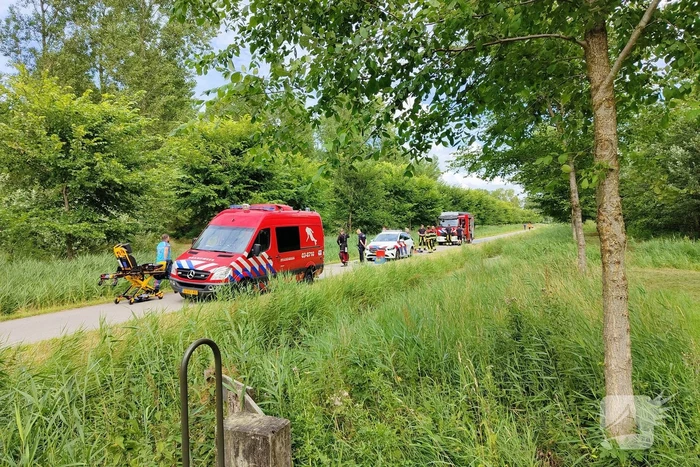 Vrouw rijdt met driewieler de sloot