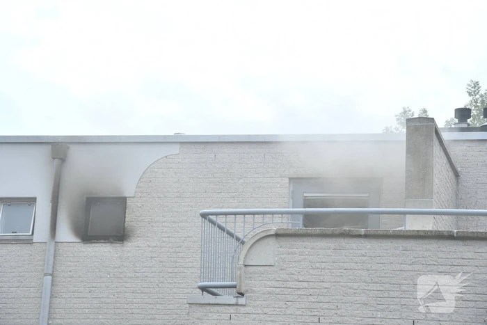 Zwarte rook uit woning door brand