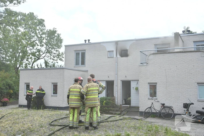 Zwarte rook uit woning door brand
