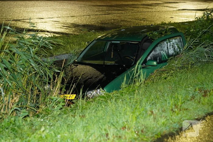 Auto glijdt de bocht uit in een sloot