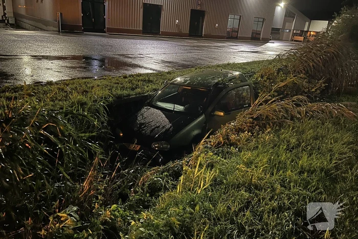 Auto glijdt de bocht uit in een sloot