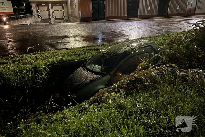 Auto glijdt de bocht uit in een sloot