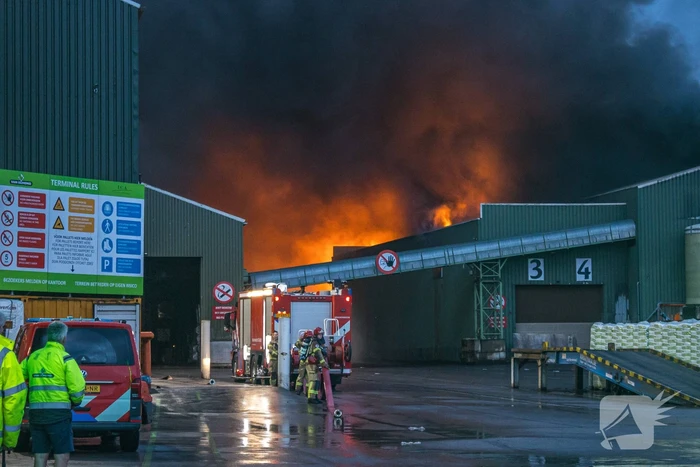 Zwarte rookpluimen boven havengebied door grote brand