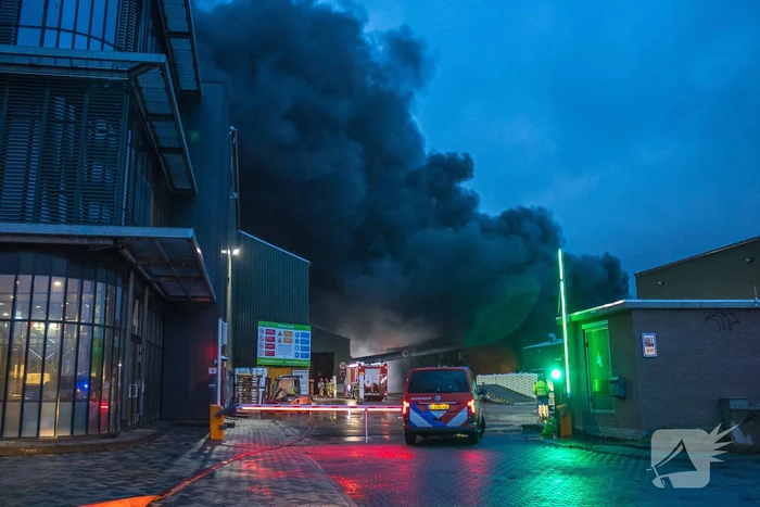 Zwarte rookpluimen boven havengebied door grote brand