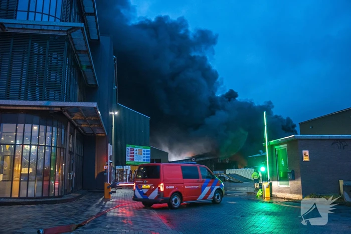 Zwarte rookpluimen boven havengebied door grote brand