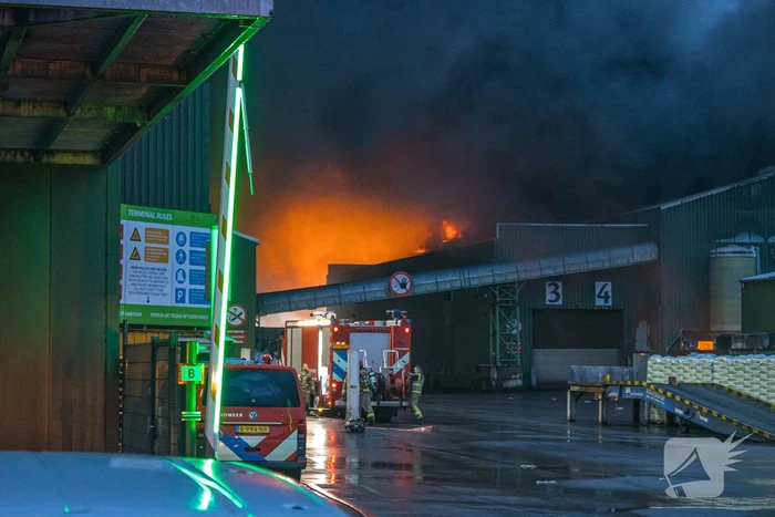 Zwarte rookpluimen boven havengebied door grote brand