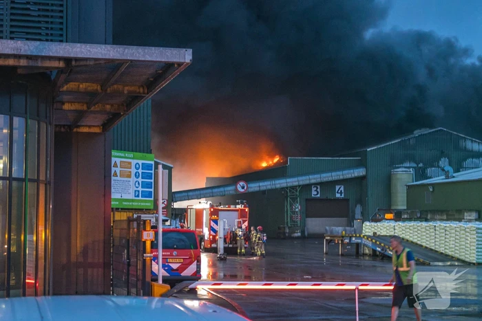 Zwarte rookpluimen boven havengebied door grote brand