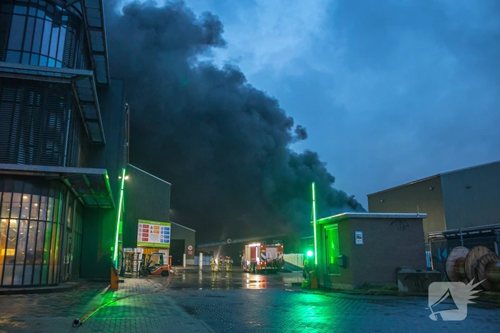 Zwarte rookpluimen boven havengebied door grote brand