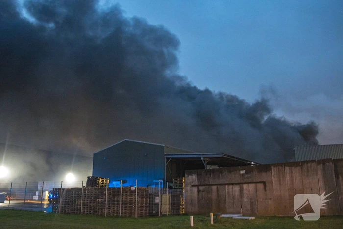Zwarte rookpluimen boven havengebied door grote brand